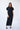 a female model wearing long navy blue yvy plisse dress 