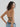 back view of model wearing black yvy leather wrap bra with denim jeans