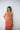 female model wearing yvy leather minimalist harness two tone in white over an orange satin maxi dress
