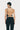 a female model wearing black yvy leather halter neck top with open back and black pants, back view